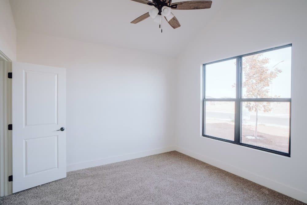 Empty carpeted bedroom with a large window