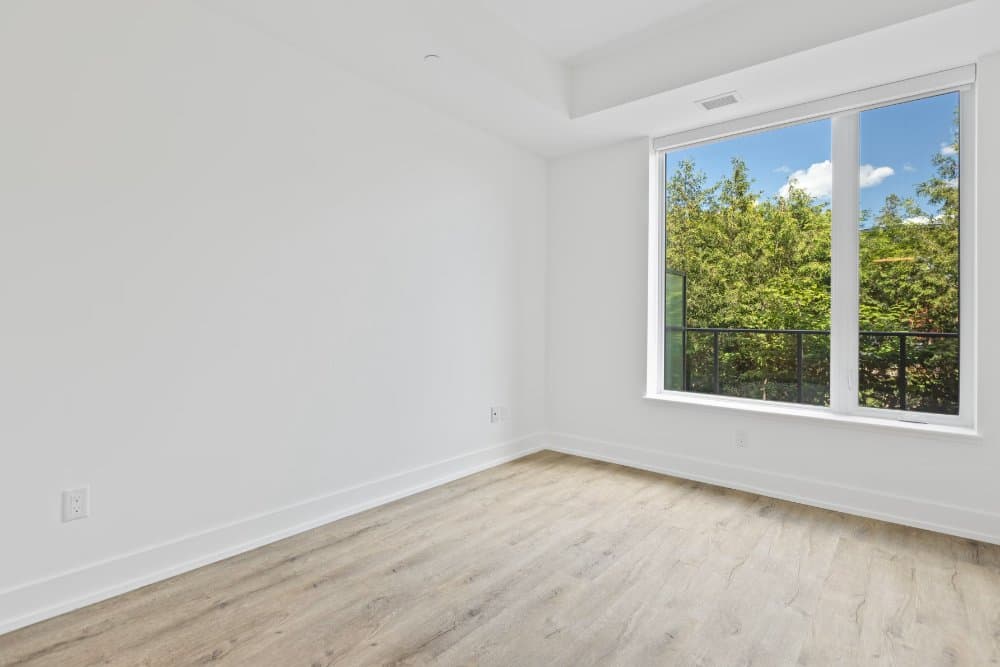 Empty bedroom with a large window onto trees